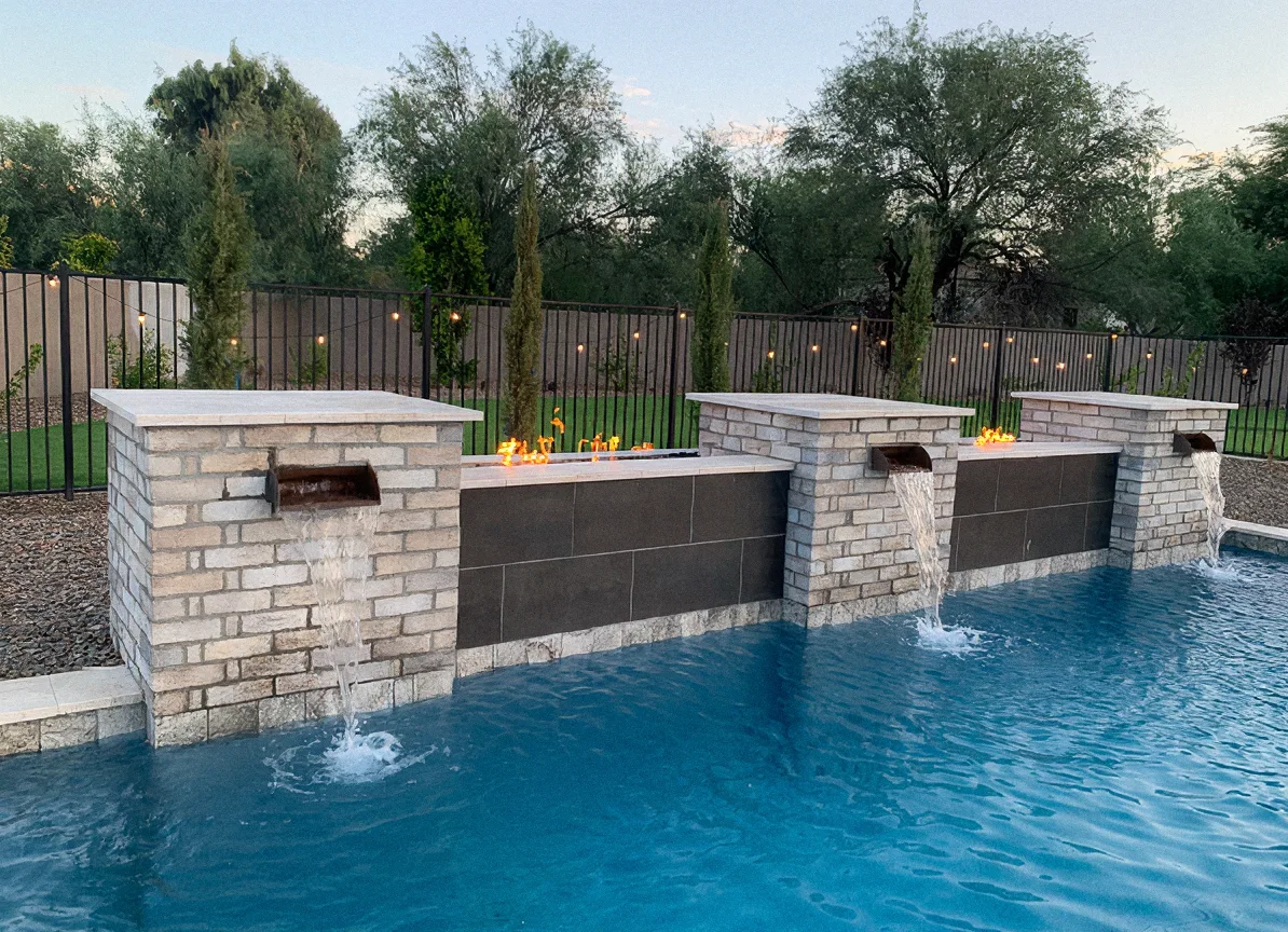 Stone and tile water feature wall with fire troughs above a pool